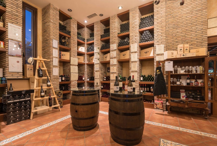 stacked bottles in the wood wall at illuminated 'Lykos Winery' tasting room